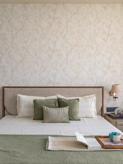 A frontal view of the custom bed with its faux leather headboard and matching side tables. The simple, clean design is complemented by the textured wallpaper and elegant wall sconces, creating a balanced and restful space.