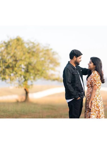 A simple, beautiful portrait of a couple in a wide-open field, capturing a moment of quiet connection.