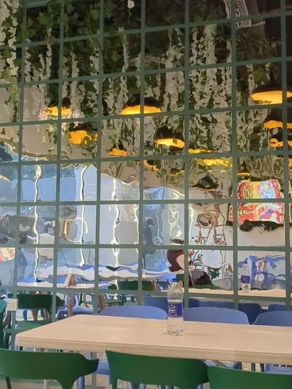 A look at the unique mirrored wall with a green grid, which adds a modern and artistic touch to the restaurant's decor.