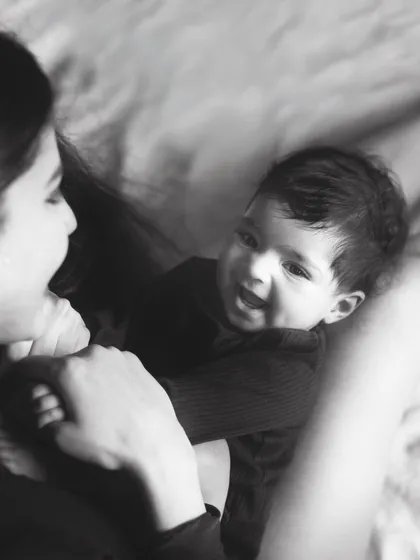 The pure joy in a baby's smile as they look up at their mother. This candid black and white shot is full of life and love.