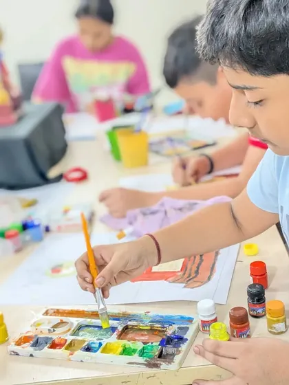 A close-up of a student carefully mixing colors on his palette. Learning color theory is a fundamental part of our curriculum.