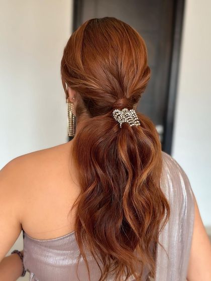 A glam low ponytail with a sparkling diamond accessory. This is a sophisticated and elegant choice for a cocktail party or reception.