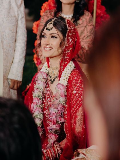 A candid shot during the Phera ceremony. The bride's smile is radiant, and her makeup looks fresh and flawless.