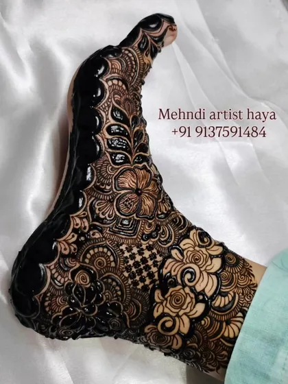 A close-up of a full-coverage foot design with the fresh paste still on. This piece combines florals, paisleys, and a checkerboard pattern for a rich, traditional look.