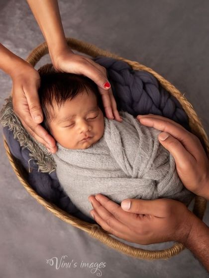 A symbolic shot of parents' hands creating a circle of love and protection around their baby. This 'hands-in' pose is a powerful way to represent family unity and safety.