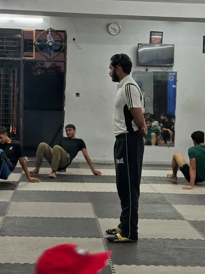Observing the group during a floor-based conditioning drill. My constant presence ensures everyone maintains proper form and intensity throughout the session.