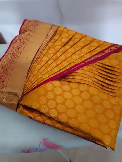 A slightly different angle of the box-folded yellow saree, ready for storage or travel.