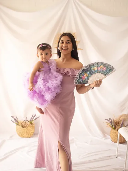 A mother and her one-year-old daughter in matching lavender tones. This pre-birthday shoot is full of smiles and sweet moments.