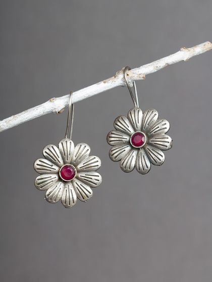 Simple yet beautiful, these oxidized silver flower studs with a red stone center are perfect for adding a touch of color to your everyday look.