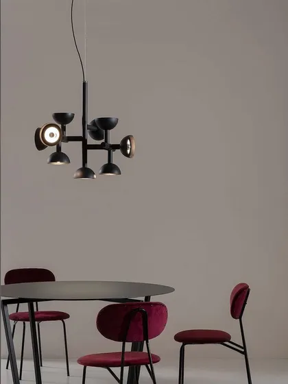The Sibilla suspension light by Karman. From a central aluminum stem, arms branch out, ending in spherical caps that diffuse light in all directions, a clear reference to Dutch neoformalism.