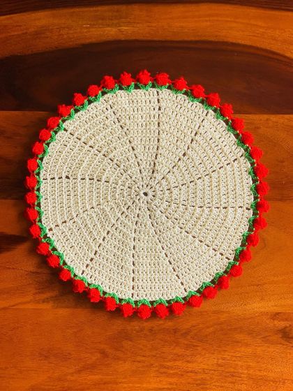 A large cream-colored placemat with a red tulip border, perfect for a single place setting.