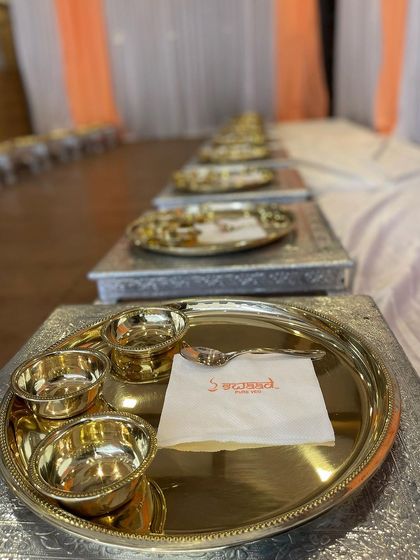 The warm glow of the gold thalis against the clean white linen creates an inviting and luxurious ambiance for your celebration's feast.