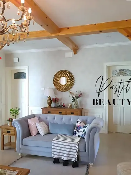 This living room has a soft, pastel beauty with its light blue sofa, floral cushions, and classic wooden furniture, creating a charming and cozy atmosphere.
