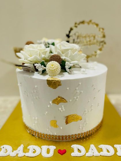 A side view of the sophisticated anniversary cake for grandparents, showing the clean design and delicate floral arrangement.