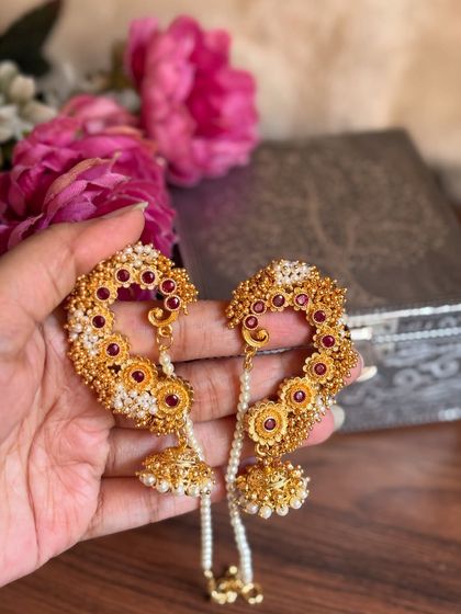 Our floral-themed karnful with red stones and golden beads. The attached pearl chain provides support and adds to the beauty of the piece.