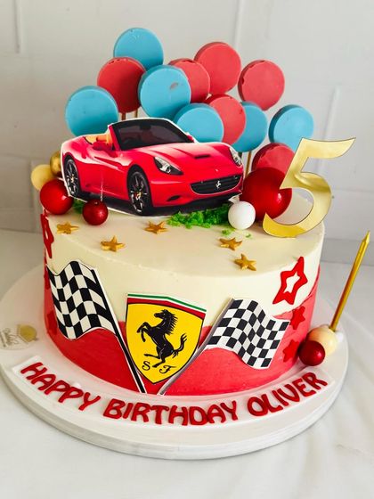 A vibrant Ferrari cake for a 5th birthday, decorated with the Ferrari shield and checkered flags.