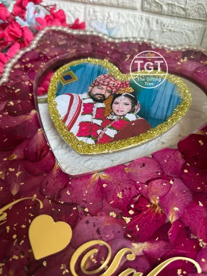 A close-up of a heart-shaped photo cutout within a larger 12x16 inch frame. The photo is bordered with gold glitter for an extra sparkle.