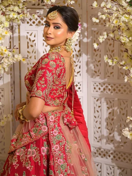 A graceful over-the-shoulder glance that highlights the complete bridal ensemble. The makeup is designed to complement the stunning back details of the blouse and the overall regal feel of the outfit.