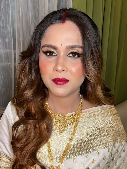 A confident and happy new mom, looking stunning in her white and gold saree.