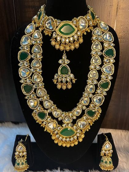 A full view of the stunning green Kundan bridal set. You can see how the choker and the layered rani haar are designed to be worn together for a grand effect. The matching maang tikka and jhumkas complete this beautiful rental set.