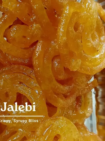Crispy, syrupy bliss is the only way to describe our Jalebi. This image captures the glossy texture of the sugar syrup clinging to the freshly fried spirals. It's a perfect dessert for any celebration.