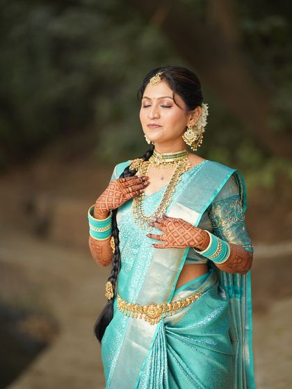 An eyes-closed shot focusing on the flawless makeup and the peaceful expression of the bride. The long, decorated braid is a key feature of this look.