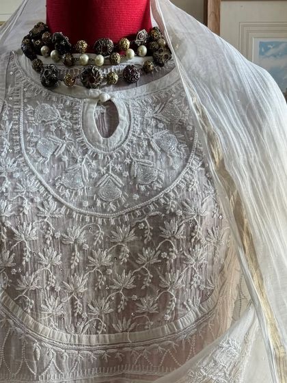 A close-up of the neckline, styled with a statement necklace to illustrate its versatility for festive events.