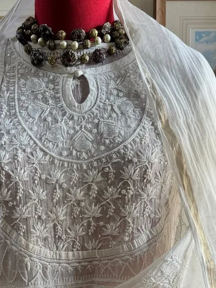 A close-up of the neckline, styled with a statement necklace to illustrate its versatility for festive events.