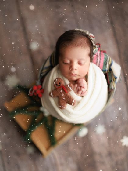 Baby's first Christmas. I love creating festive holiday-themed shots. This little one is wrapped up like a present with a tiny gingerbread man, ready for the most wonderful time of the year.