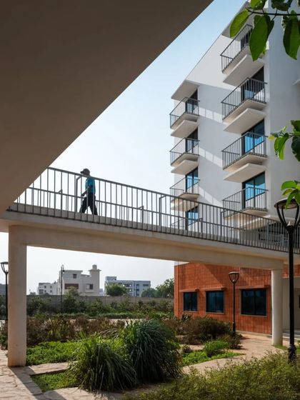 An elevated walkway at the Srishti campus passes over a landscaped area. This layering of movement and nature is central to our campus design philosophy.