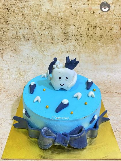 A cute cake to celebrate a baby's first tooth. The smiling tooth character and little tooth decorations make for a unique and memorable celebration.