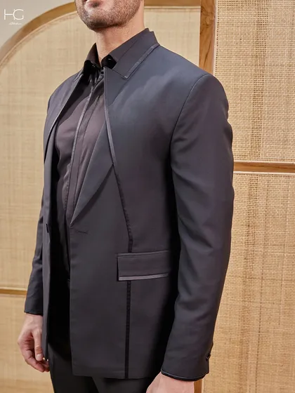 This close-up shows the craftsmanship of the lapel and pocket details. It's these small, precise touches that elevate a black suit from standard to statement.