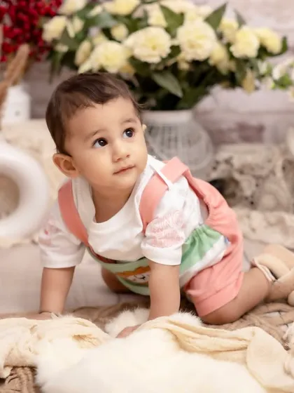 On the move. This shot captures a baby during their crawling phase, exploring a beautiful floral set. It's a perfect way to remember their first big steps toward independence.