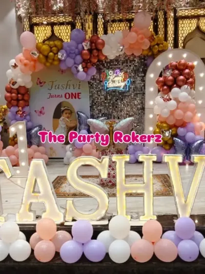 For this grand first birthday, I used large, illuminated marquee letters to spell out the birthday girl's name. The butterfly theme was completed with a sequin backdrop, a pastel balloon arch, and fairy cutouts.