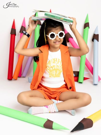 Another playful pose with a book, showing the versatility of the props and the child's imagination.