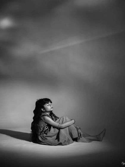 A dramatic and thoughtful portrait. The use of negative space and soft lighting creates a contemplative mood, highlighting her ability to hold a scene with just her presence.