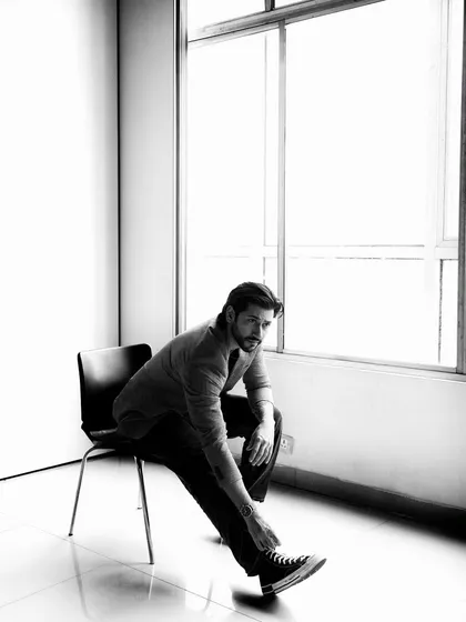 A dynamic black and white pose that feels both casual and intense. The natural light from the window creates a beautiful soft-edged shadow.
