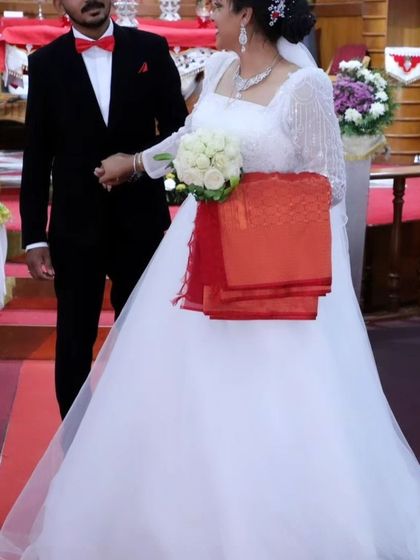 Another look at Jittu's beautiful custom gown during her wedding ceremony. The flowing train and classic silhouette create a truly timeless bridal look.