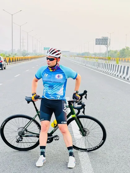 A cyclist posing on a wide, empty highway. These are the moments of freedom we ride for.
