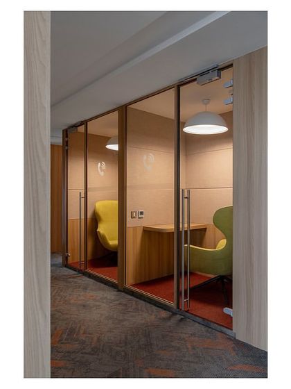 These telephone booths in 'The Office with A View' offer employees a private, sound-absorbed space for calls. We used vibrant, comfortable chairs and focused lighting to make these small spaces functional and inviting.