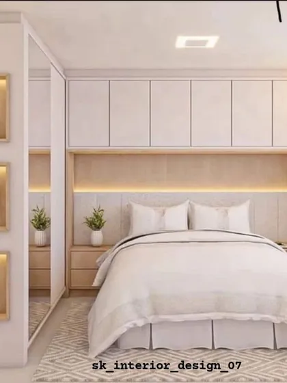 A bright and airy bedroom with white wardrobes built around the bed. The illuminated display niches on the side add a personal touch and soft ambient light.