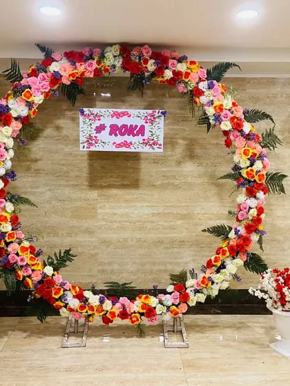 This is a simple yet elegant backdrop I created for a Roka ceremony. The large circular arch is covered in a mix of colorful, high-quality artificial flowers, providing a beautiful focal point for the couple's first official celebration.