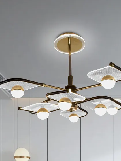 This chandelier features six arms with glass panels and globe lights, creating a wide spread of light. The design is modern with a touch of retro style, making it a versatile piece for various interior themes.