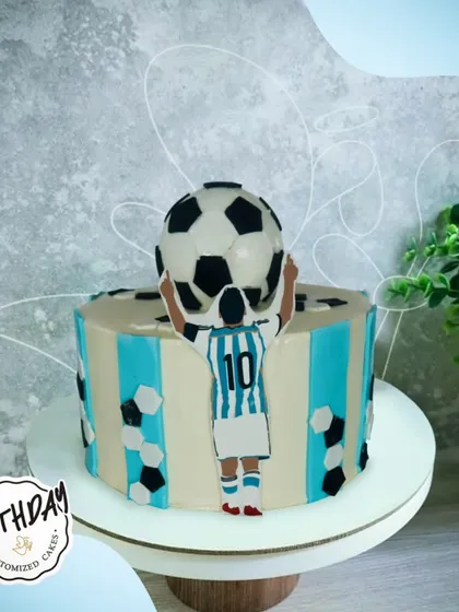 A winning football-themed cake, featuring a player holding a soccer ball aloft in victory. A great design for a passionate player or fan.