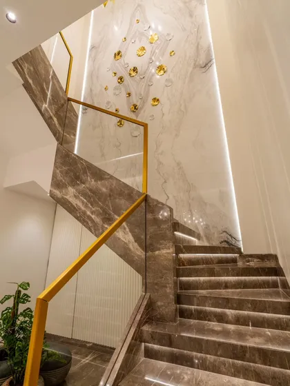 The magnificent marble staircase with its golden handrail and integrated LED lighting. This is a central feature of the home, designed to be both a functional element and a work of art.
