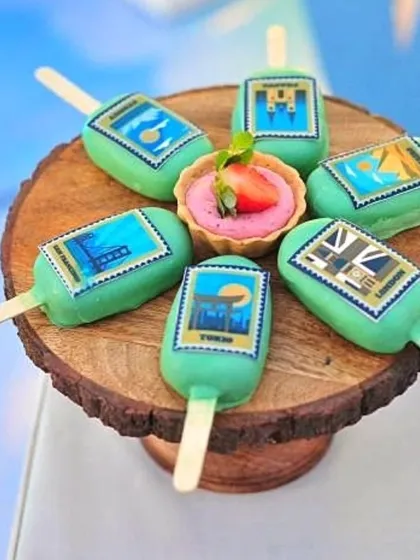 A display of the travel-themed cakesicles and strawberry tarts.
