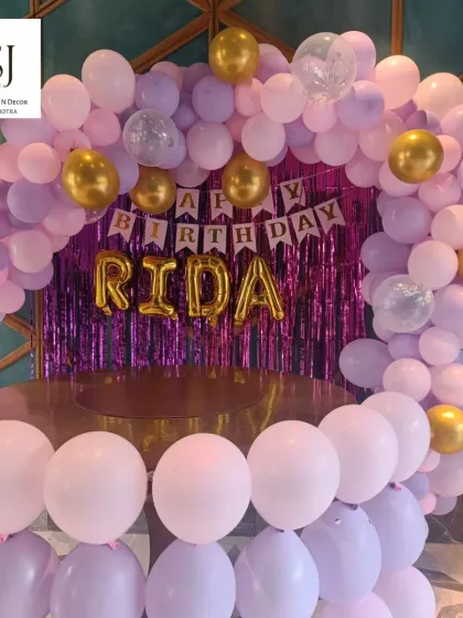 This pink and purple balloon arch was for Rida's birthday. The setup included a shimmer backdrop and her name in gold foil letters, creating a glamorous and fun photo spot in Gurgaon.