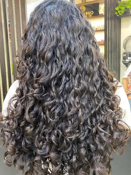 This is the goal: a full head of beautifully defined, healthy, and hydrated curls. This result was achieved by understanding the client's specific hair type and creating a routine that she can replicate at home.