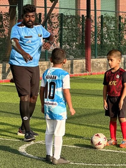 A coach guides a player during a Blue Cubs league game. We provide constant support and instruction on the field.