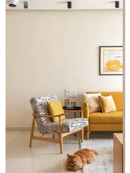 The living room of 'Penny's Home', where spatial design is crucial. The abstract-patterned armchair and mustard sofa create a playful yet harmonious composition.